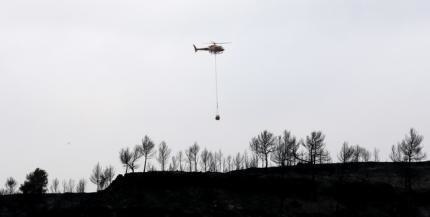 Požiare sužujú Španielsko už dlhšie. Helikoptéra dováža na postihnuté miesta vodu na hasenie.