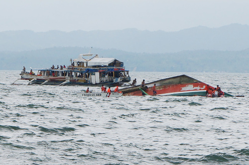 Záchranári pomáhali ľuďom z prevráteného trajektu na filipínskom ostrove Leyte.