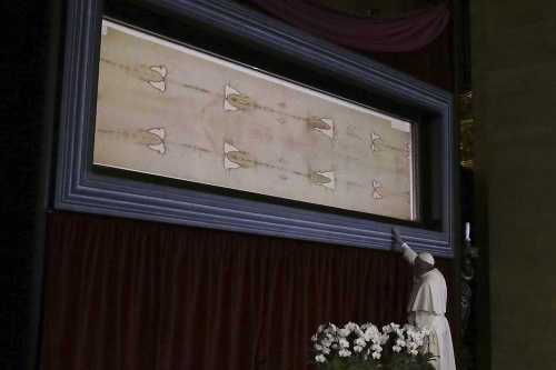 Pápež František modliaci sa pred Turínskym plátnom, ktoré je viac ako 4 metre dlhé a považované sa sväté.