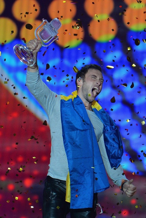 Mans Zelmerlöw zo Švédska sa raduje s trofejou po víťazstve vo finále súťaže Eurovision Song Contest s pesničkou Heroes 24. mája 2015 vo Viedni.