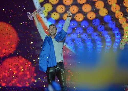 Mans Zelmerlöw zo Švédska sa raduje s trofejou po víťazstve vo finále súťaže Eurovision Song Contest s pesničkou Heroes 23. mája 2015 vo Viedni. 