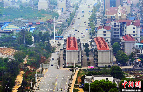 Čína: Apartmány v Changshi nútia autá už niekoľko rokov prejsť zo štvorprúdovej cesty do jednoprúdovej.