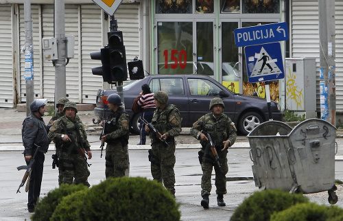 Policajti sú na ulici v macedónskom meste Kumanovo, kde prebiehajú boje medzi policajnými silami a členmi ozbrojenej skupiny, v sobotu 9. mája 2015.