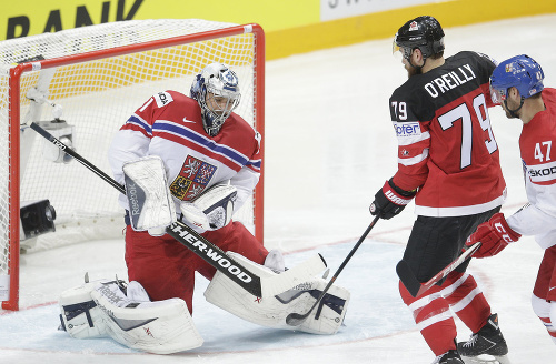 Český brankár Ondřej Pavelec (vľavo) chytá puk z hokejky Kanaďana Ryana O’Reillyho.