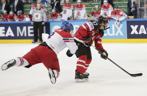 Kanadský hráč Sidney Crosby (vpravo) dostáva úder hokejkou do tváre od Čecha Jana Hejdu. 