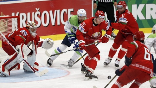 Bieloruskí a slovinskí hráči bojujú o  puk pred bránkou Bieloruska.