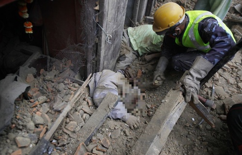 Záchranári vyťahujú z trosiek obete zemetrasenia.