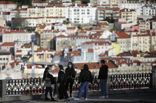 Ľudia stoja na mieste s výhľadom na staré centrum 11. marca 2021 v Lisabone.