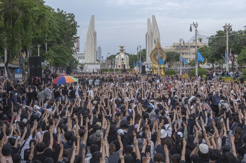 Prodemokratickí aktivisti zdvíhajú tri prsty ako symbol odporu počas zhromaždenia 16. augusta 2020 v Bangkoku.