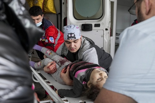 Záchranári prevážajú zranené dievča po ruskom útoku v Mariupole. Podľa agentúry AP neprežilo.