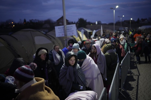 Utečenci utekajúci pred vojnou zo susednej Ukrajiny stoja v rade na hraničnom priechode Medyka v Poľsku.