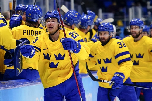 Švédsky hokejista Lucas Wallmark (v popredí) sa teší po strelení gólu počas štvrťfinálového zápasu Švédsko - Kanada na ZOH 2022 v Pekingu