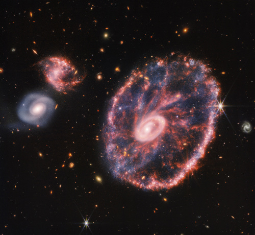 Na snímke zverejnenej americkým Národným úradom pre letectvo a vesmír (NASA) sa nachádzajú galaxie zaznamenané vesmírnym teleskopom Jamesa Webba v utorok 2. augusta 2022. Vpravo sa nachádza veľká ružová škvrnitá galaxia, ktorá pripomína koleso a v jej vnútri sa nachádza menší ovál obklopený prachom modrej farby, vľavo sú viditeľné dve špirálové galaxie približne rovnakých rozmerov.