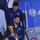 Argentínsky futbalista Lionel Messi drží trofej pre víťaza MS vo futbale počas vystupovania z lietadla v Buenos Aires.