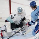 Slovenský hokejista Montrealu Canadiens Juraj Slafkovský (uprostred) a brankár Seattle Kraken Martin Jones počas zápasu zámorskej NHL.