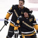 Bývalý hokejista Pittsburghu Penguins Jaromír Jágr (vľavo) a kapitán  Pittsburghu Penguins Sidney Crosby sa rozcvičujú po slávnostnom vyvesení dresu.