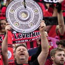 Fanúšik Bayeru Leverkusen drží repliku trofeje.