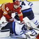 Slovenský hokejista Samuel Honzek (vľavo) z Calgary Flames v súboji pred bránkou.