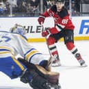 Na snímke vpravo Jack Hughes v drese New Jersey Devils a vľavo brankár Devon Levi z Buffala Sabers.