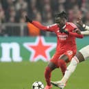 Hráč Bayernu Alphonso Davies  (vpravo) bojuje o loptu s Issom Kaboreom z Benficy.