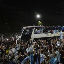 Hráči argentínskej futbalovej reprezentácie mávajú fanúšikom z autobusu po prílete v Buenos Aires.