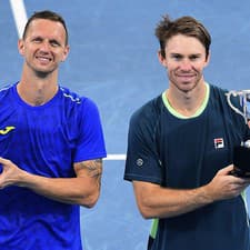 Slovensko-austrálsky pár Filip Polášek (vľavo) a John Peers (vpravo) pózujú s trofejou po zisku titulu v mužskej štvorhre na turnaji ATP v Sydney.