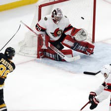 Hokejista Bostonu Bruins David Pastrňák (vľavo) strieľa gól v zápase zámorskej hokejovej NHL Boston Bruins - Ottawa Senators.