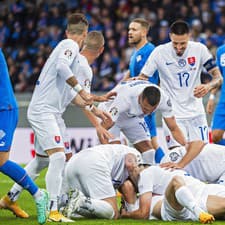 Slovenskí futbalisti sa tešia z gólu.