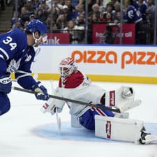 Juraj Slafkovský (vľavo) sa snaží atakovať útočníka Toronta Austona Matthewsa.