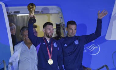 Argentínsky futbalista Lionel Messi drží trofej pre víťaza MS vo futbale počas vystupovania z lietadla v Buenos Aires.