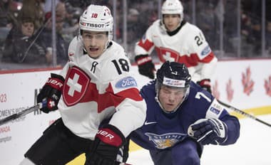 Švajčiarsky hokejista Nicolas Perrenoud v súboji o puk s Fínom Aleksim Ervastim počas zápasu B-skupiny na hokejových MS do 20 rokov