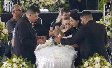 Marcia Aokiová, vdova po zosnulom brazílskom futbalovom velikánovi Pelém, drží ruženec nad jeho telom.