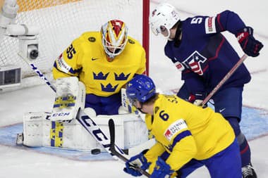 Švédsky brankár Carl Lindbom(vľavo), hráč USA Rutger McGroarty (uprostred) a hokejista Švédska Victor Sjöholm v zápase o 3. miesto Švédsko - USA na MS hráčov do 20 rokov.
