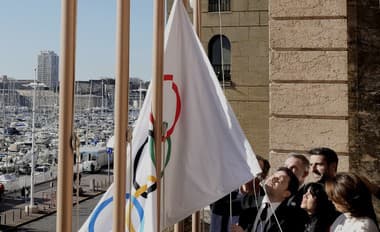 Starosta Marseille Benoit Payan (vľavo) vztyčuje olympijskú vlajku so šéfom olympijského výboru OH 2024 v Paríži Tonym Estanguetom (uprostred vpravo). (ilustračná fotografia)