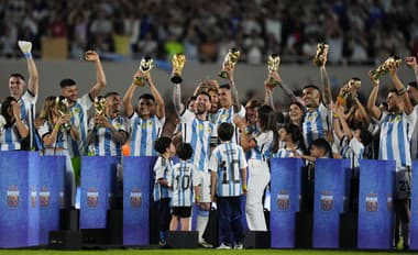 Hráč Lionel Messi z Argentíny drží repliku trofeje pre víťaza MS vo futbale počas osláv pre fanúšikov.