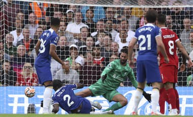 Hráč Chelsea Axel Disasi (druhý zľava) strieľa vyrovnávajúci gól na 1:1 cez brankára Liverpoolu Alissona (uprostred).