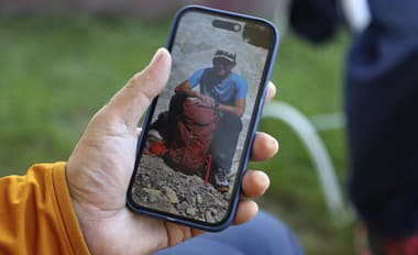 Japonský horolezec Semba Takajasu ukazuje na displeji svojho mobilu svojho krajana Šindži Tamuru.