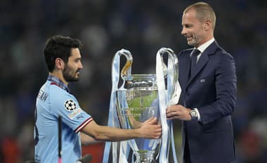 Šéf UEFA Aleksander Čeferin odovzdáva ušatú trofej kapitánovi Manchestru City Ilkayovi Gündoganovi.