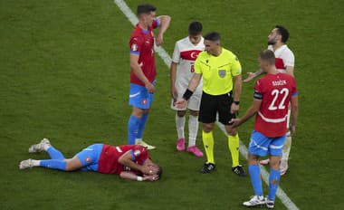 Český futbalista Vladimír Coufal leží zranený na zemi.