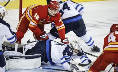 Slovenský hokejista Samuel Honzek (vľavo) z Calgary Flames v súboji pred bránkou.