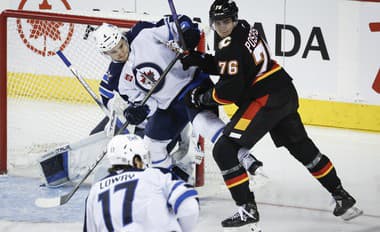 Neal Pionk (Winnipeg) a Martin Pospíšil (Calgary) v súboji pred bránkou.