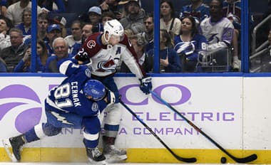 Slovenský hokejista v drese Tampy Bay Lightning Erik Černák (vľavo) a hráč Colorada Avalanche Nathan MacKinnon bojujú o puk.