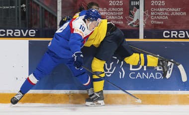  Hokejista Slovenska Tomáš Pobežal (vľavo) a hráč Švédska Theo Lindstein bojujú puk pri mantineli.