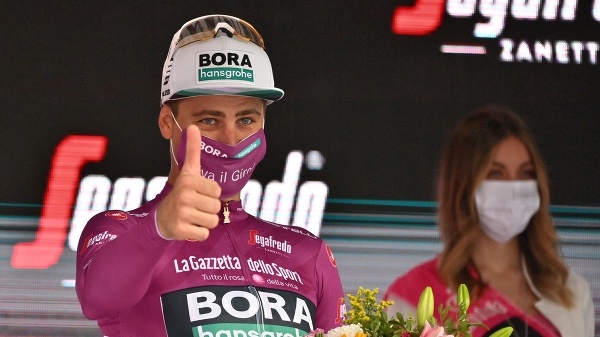 Peter Sagan z tímu Bora-Hansgrohe oslavuje na pódiu cyklámenový dres vedúceho pretekára na Giro d'Italia.