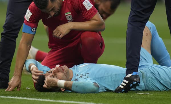 Zranený iránsky brankár Alírezá Baíranvánd leží na trávniku počas zápasu základnej B-skupiny Anglicko - Irán