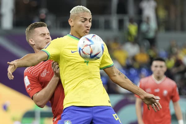 Brazílsky futbalista Richarlison (uprostred) a švajčiarsky futbalista Nico Elvedi počas zápasu základnej G-skupiny Brazília - Švajčiarsko na majstrovstvách sveta vo futbale.