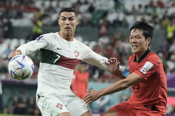 Portugalský futbalista Cristiano Ronaldo (vľavo) a juhokórejský futbalista Kim Jong-kwon v súboji o loptu.