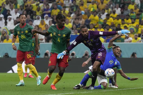 Brazílsky hráč Rodrygo (vpravo), proti nemu kamerunský hráč Christopher Wooh (druhý zľava) a kamerunský brankár Devis Epassy (druhý sprava).
