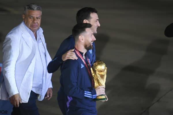 Argentínsky futbalista Lionel Messi drží trofej pre víťaza MS vo futbale počas vystupovania z lietadla v Buenos Aires.