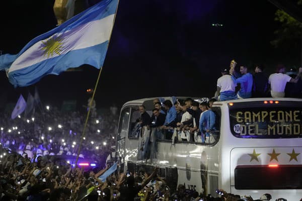 Hráči argentínskej futbalovej reprezentácie mávajú fanúšikom z autobusu po prílete.